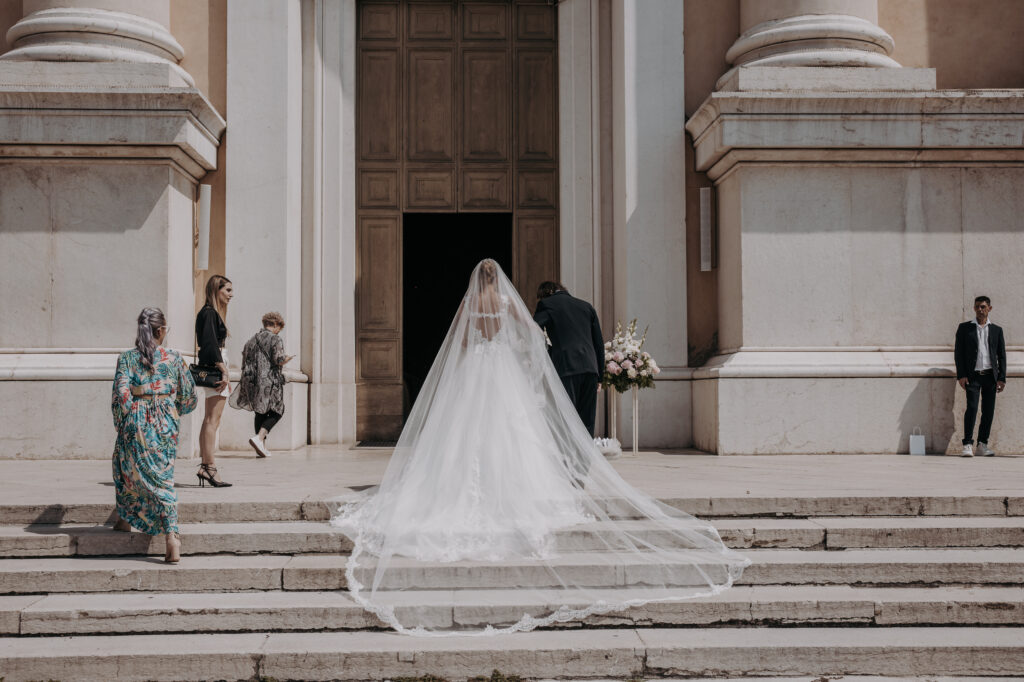 panoramica del vestito della sposa  fuori dalla chiesa 